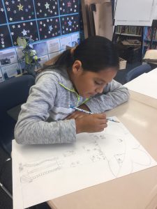 Hard at work, a Mabel Paine student draws her dream tree-house.