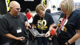 Supporters of Tuffree Middle School look through an old yearbook at the school's 50th anniversary celebration. Photo courtesy of teacher John Miller.
