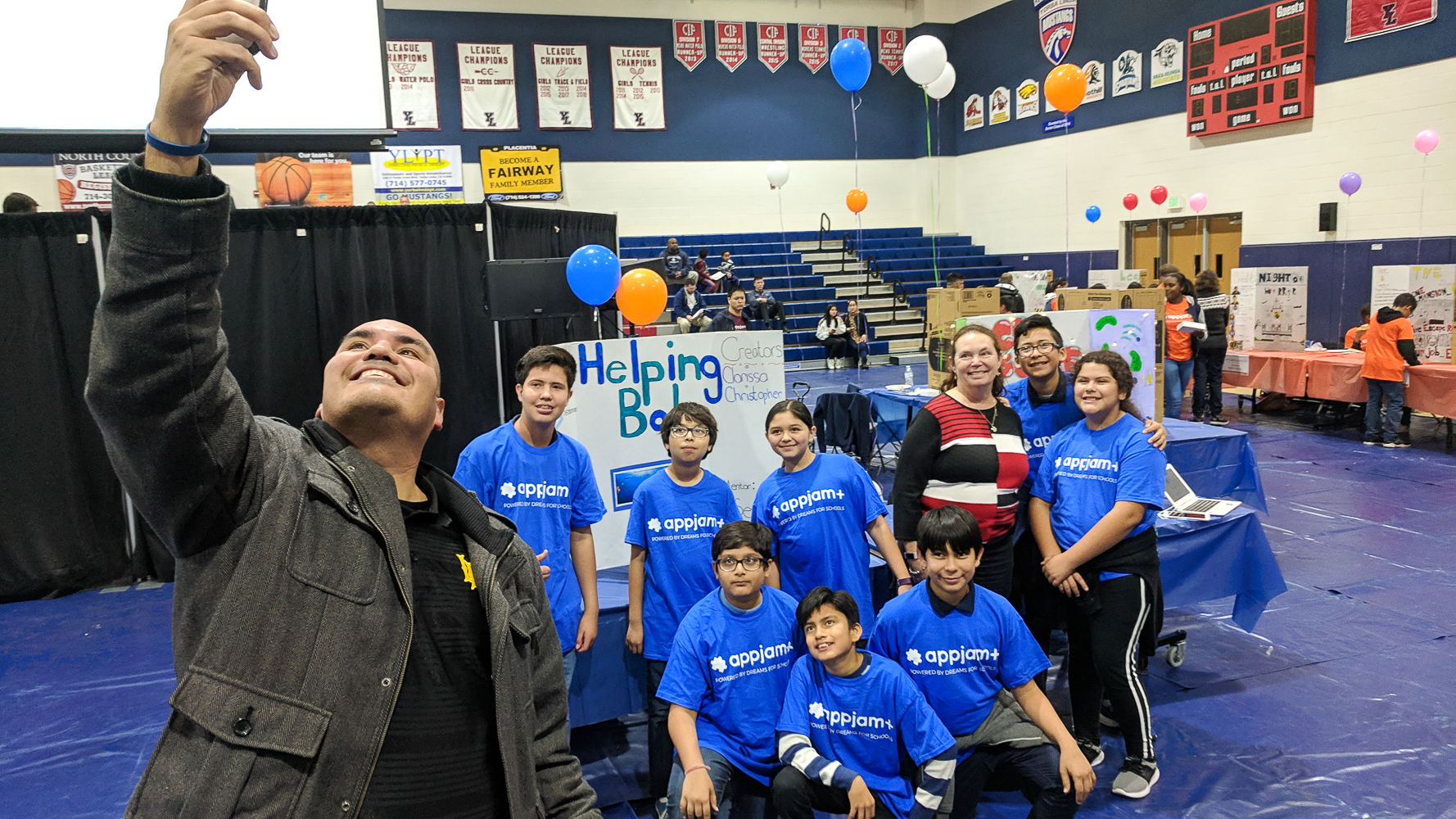 Valadez Middle School Academy principal, Cuco Gracian, snaps a selfie with a few of his students at the AppJam+ Fall Showcase Finale.