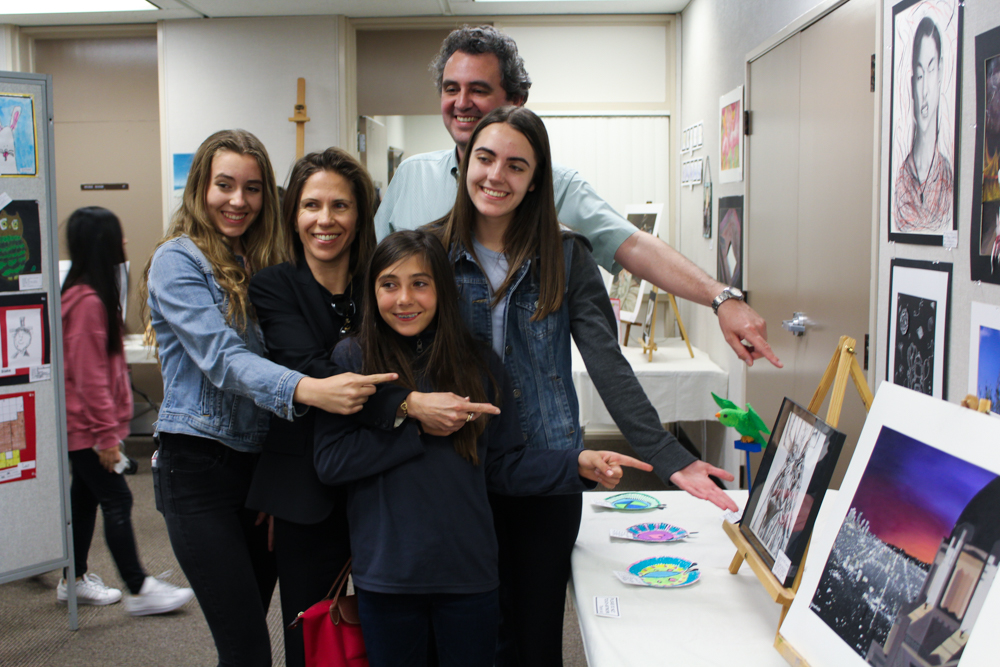 A PYLUSD family proudly points to their student's masterpiece at the ArtWorks! Exhibition Opening Reception last year in 2018. This year's Opening Reception will be Wednesday, May 1, 2019 from 6 p.m. to 8 p.m. at the Professional Development Academy in Yorba Linda.