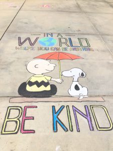 Girl covers her driveway in chalk art to bring joy in uncertain times.