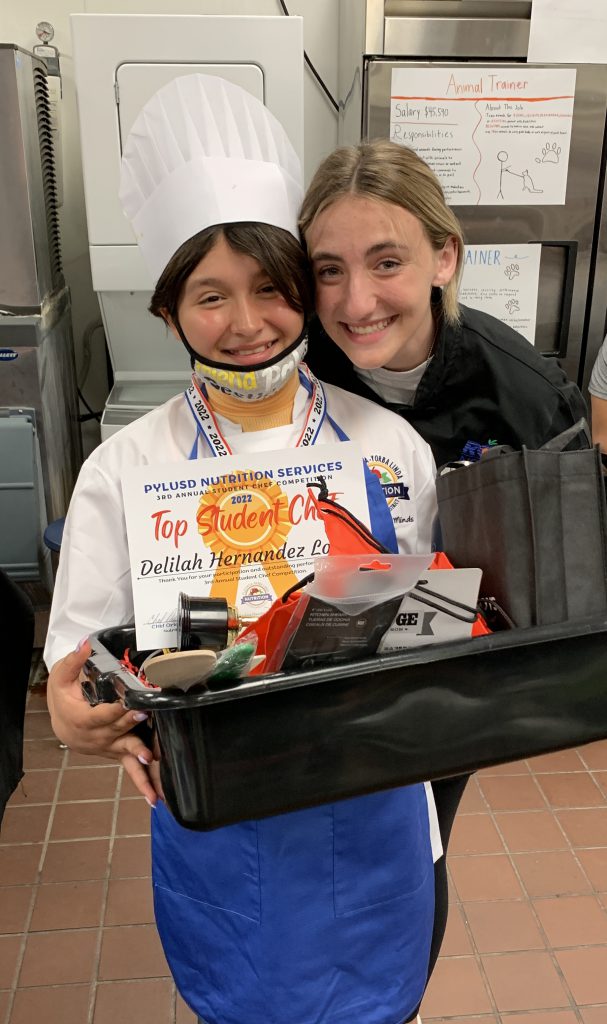Fifth grader Delilah Hernandez Lopez wins first place at the student chef competition, accompanied by Yorba Linda High School culinary student