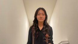 Eva Yoon from Kraemer holding a violin.