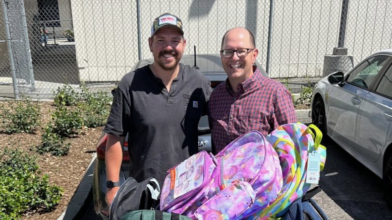 Community members drop off backpacks with school supplies.
