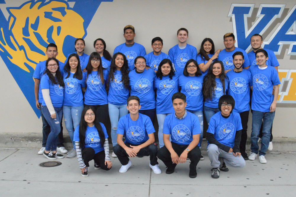 Valencia High School AVID seniors pose for a picture by the school's mural.