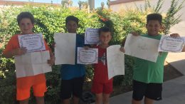 Boys hold up Global Day of Design certificates.