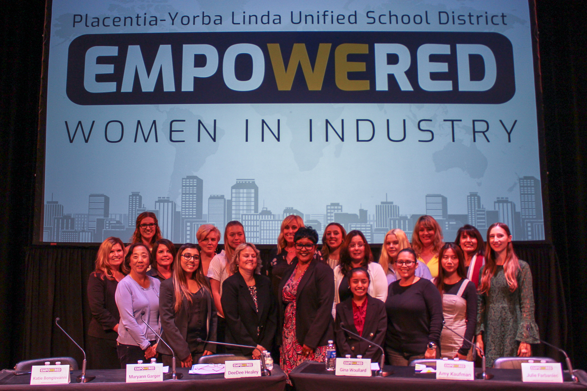 Women in Industry panelists and student moderators pose for a photo on stage.