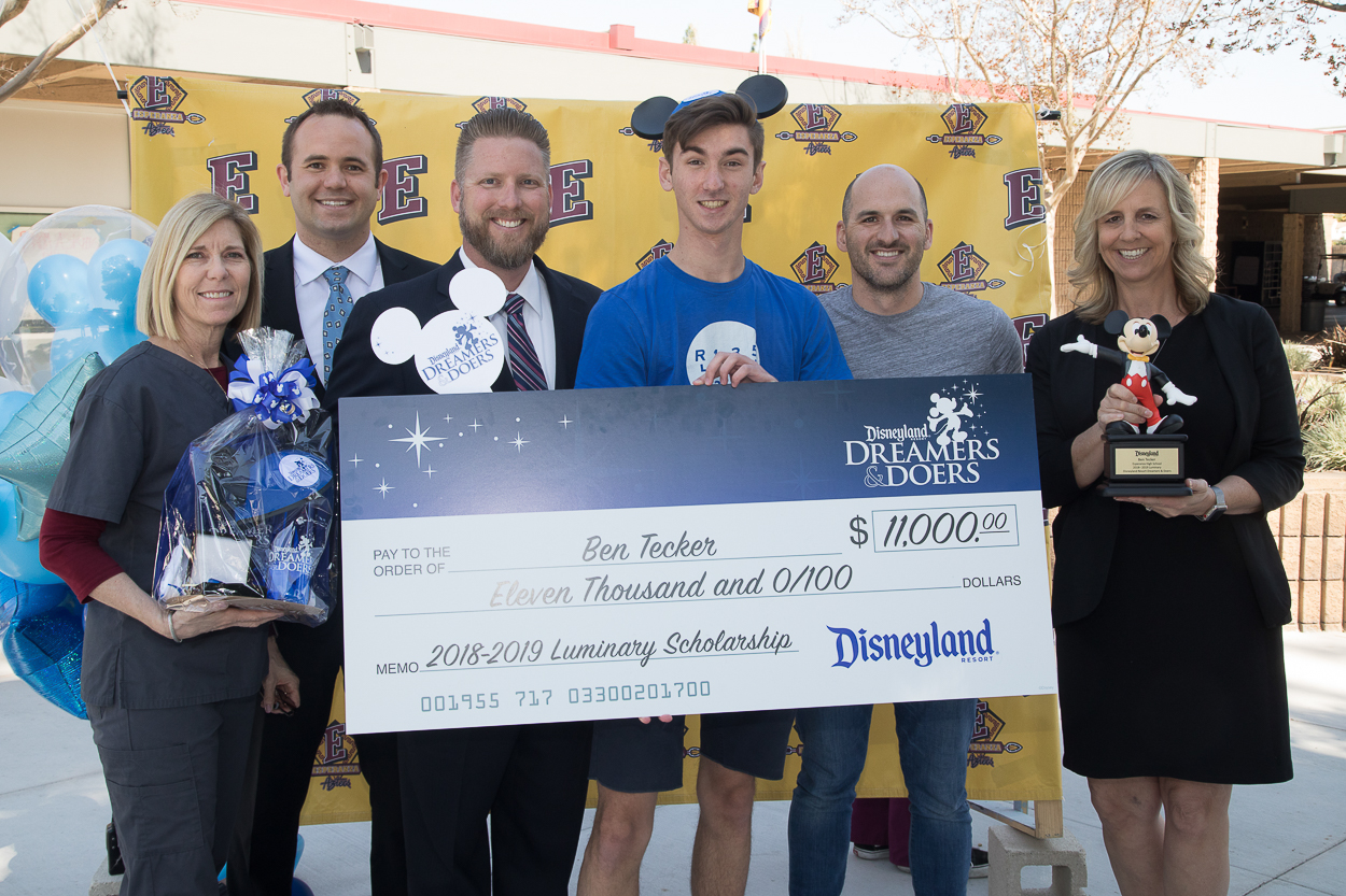 With his Mickey Mouse ears proudly on, Ben poses for a picture with his $11,000 college scholarship check and (left to right) Esperanza counselor, Brianne Gullotti, assistant principals, Connor Drake and Scott Mazurier, teacher, Brent Willis, and principal, Gina Aguilar. Ben had just received the news that he was selected as a 2018-19 Disneyland Resort Dreamers & Doers Program Luminary!